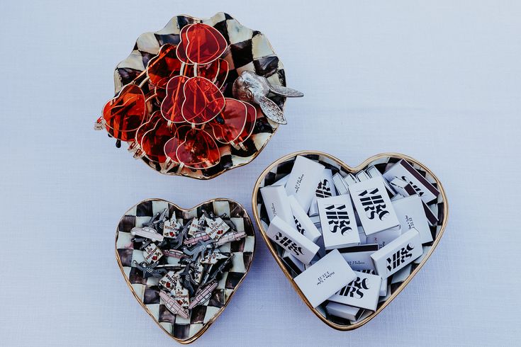 two heart shaped bowls filled with candy next to each other