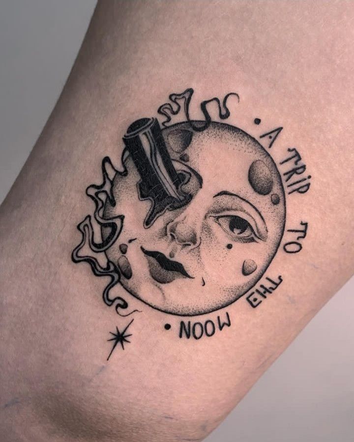 a black and white tattoo on the leg of a woman's thigh with an image of a sun and moon