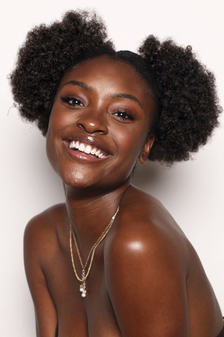 a woman with an afro is smiling for the camera