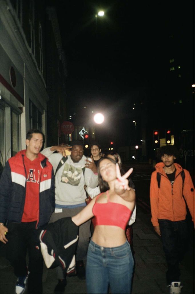 a group of people walking down a street at night