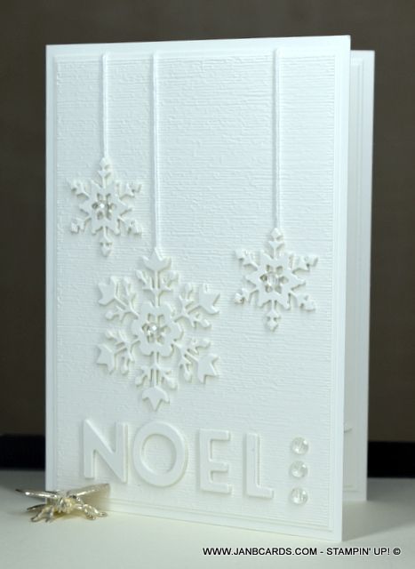 a white card with snowflakes on it and the word noel written in silver