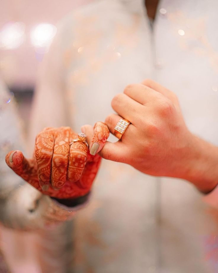 a person holding something in their hand and wearing a wedding ring on it's finger