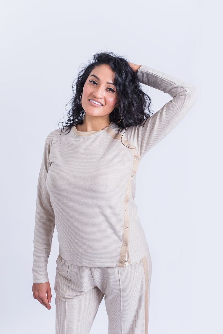 One side snap closure Sparkies cream-colored long sleeve top is made from a jersey fabric with stretch. It is perfectly adaptive with a full side opening on easy-to-use snaps, that starts at the raglan line and merges with the side seam. No collar and presence of side opening give added mobility to the garment, making it easy to pull on and off and get extra ease when needed. Stunningly fashionable and goes with any everyday outfit. Featured details: Long raglan sleeve; Sleeve 31 1/2" center bac Versatile Long Sleeve Buttoned Tops, Versatile Long Sleeve Tops With Buttons, Versatile Long Sleeve Tops For Daywear, Long Sleeve Tops With Snap Buttons, Stretch Tops With Buttons For Loungewear, Fall Daywear Tops With Snap Buttons, Fitted Loungewear Tops With Buttons, Stretch Crew Neck Blouse For Loungewear, Versatile Long Sleeve Loungewear Blouse