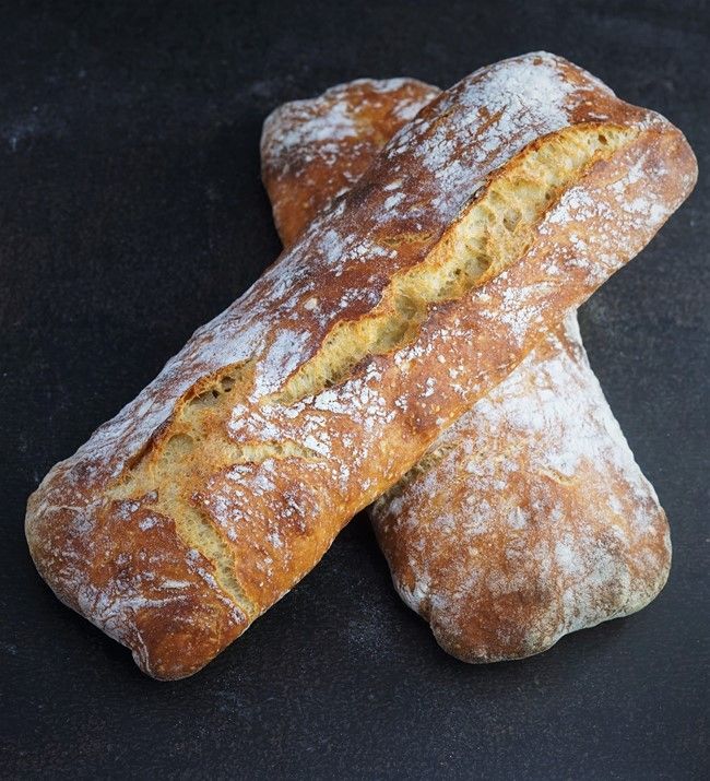 two loaves of bread on a black surface