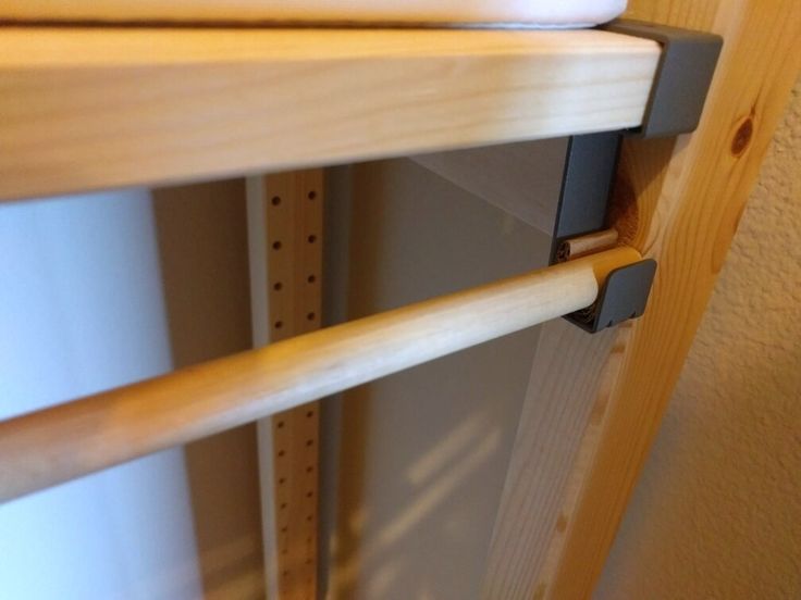 a close up of a wooden shelf with metal brackets on the top and bottom shelves