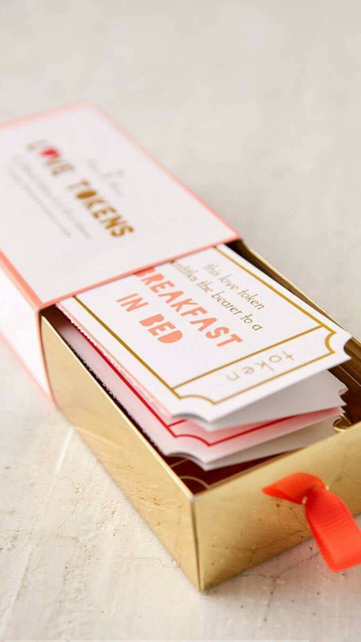 a box with some cards in it sitting on a table next to an orange ribbon