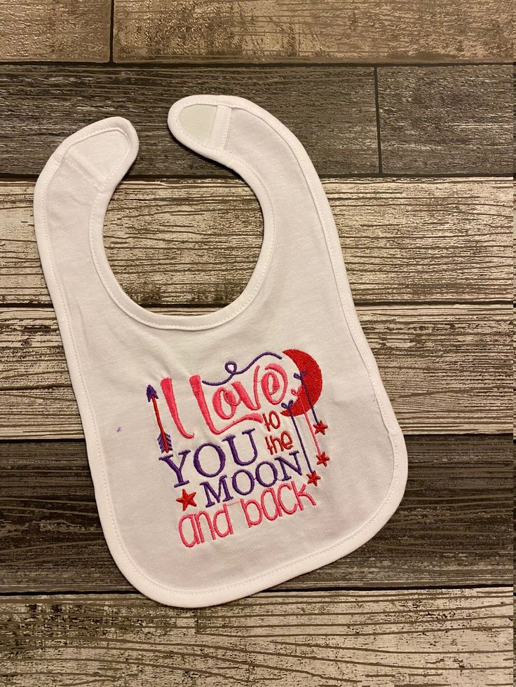 Tell everyone how you feel with our "I Love You to the Moon and Back" Bib.   This bib is available in 2 color options...One for Girls and One for Boys.  Hey. Spit and mess happens so let this bib catch it all! Beautifully embroidered on a standard infant bib and sealed with Soft cotton  on the back so none of the stitching hits the babys tender skin. All bibs are made to order. Bib is Machine Embroidered with "I Love You to the Moon and Back". ALL EMBROIDERY IS SEALED WITH SOFT COTTON BACKING fo Embroidered Bibs, Newborn Bibs, Burp Clothes, Boy Bib, Girls Bib, Gift Newborn, To The Moon And Back, Baby Shirts, Custom Baby