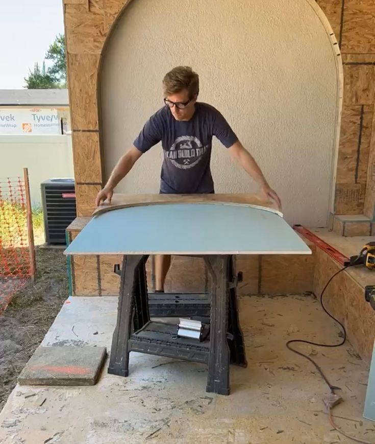 a man is making a surfboard out of plywood