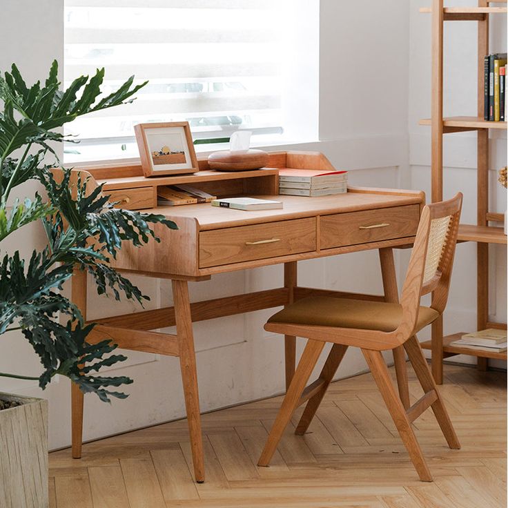 a wooden desk with a plant in front of it