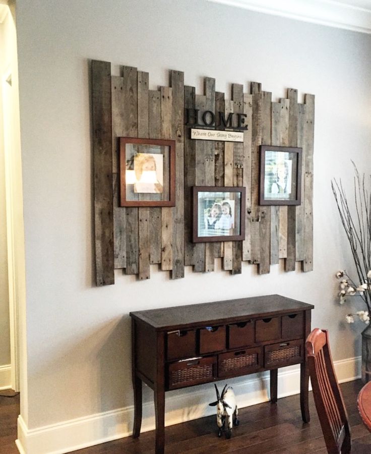 a wooden table sitting in front of a wall with pictures hanging on it's side