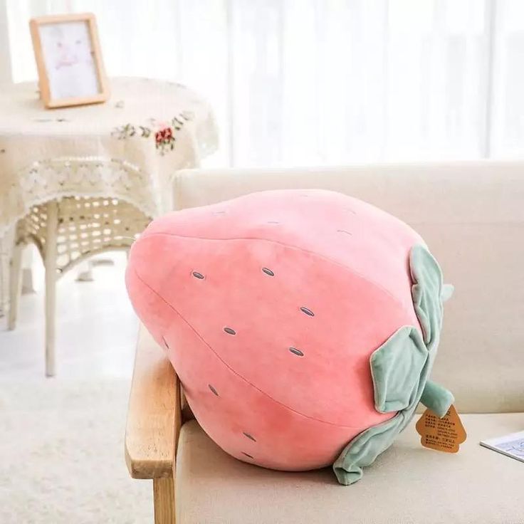 a pink pillow sitting on top of a couch