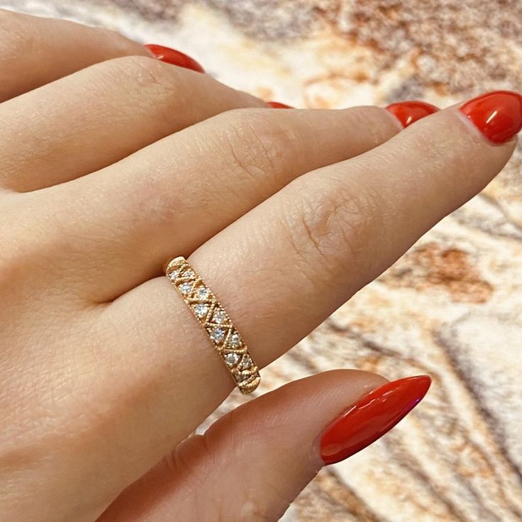 a woman's hand with red nails and a gold ring on her left hand