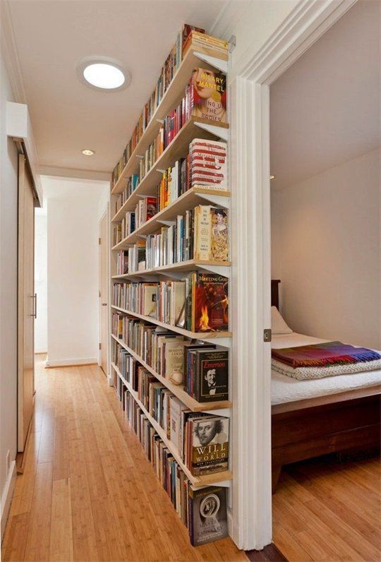 an image of a room with bookshelves on the wall and wood flooring