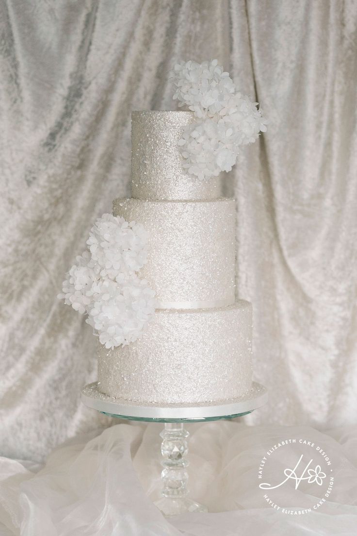 a white wedding cake with flowers on top