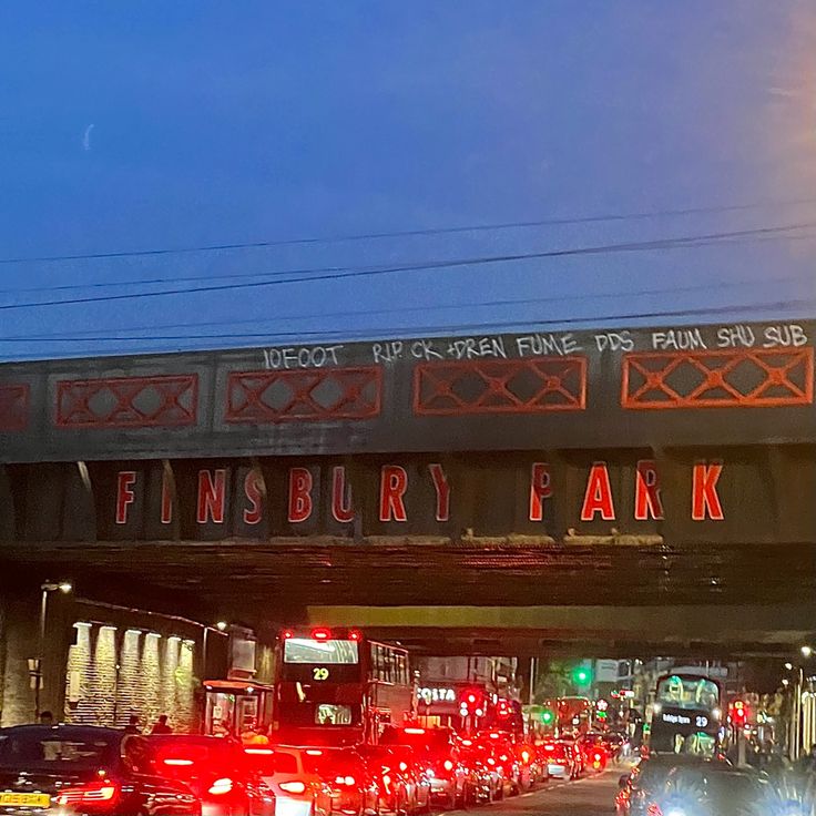 cars and trucks driving under an overpass with the word finishbury park written on it