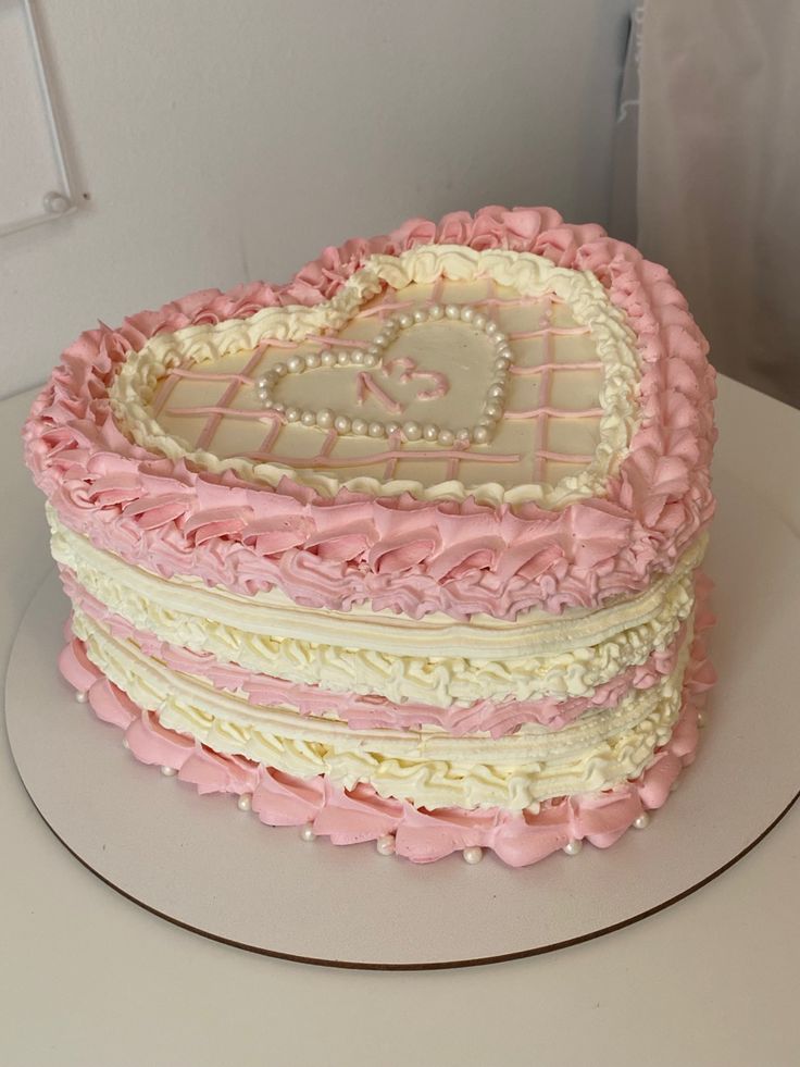 a heart shaped cake with pink and white frosting