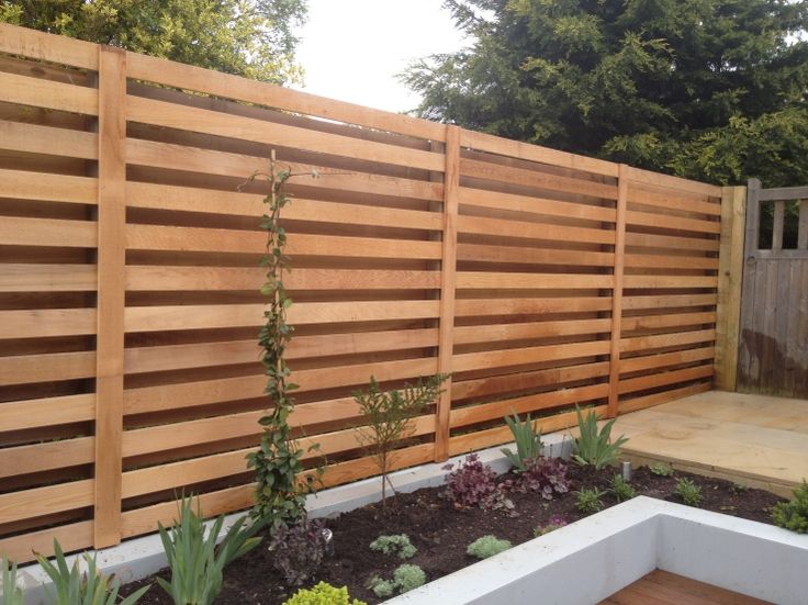 a wooden fence in the middle of a garden