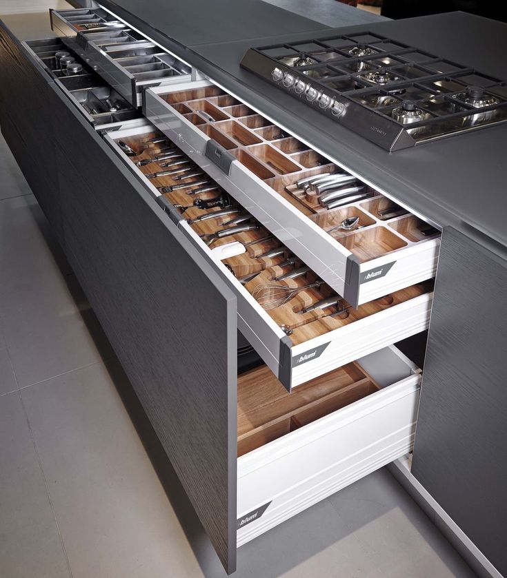 an open drawer in the middle of a kitchen