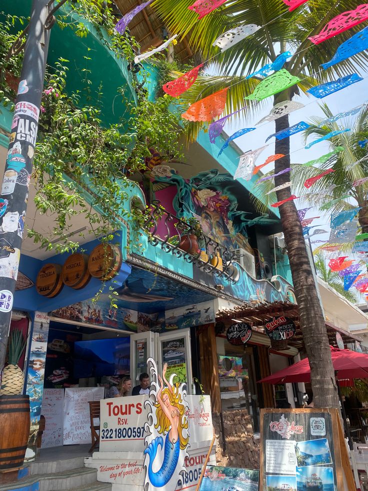 the outside of a building with palm trees in front of it and signs on the side