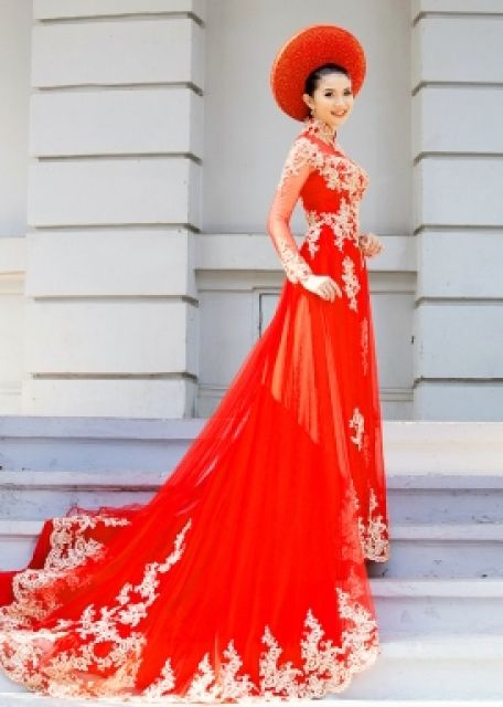 a woman in a red dress and hat standing on steps