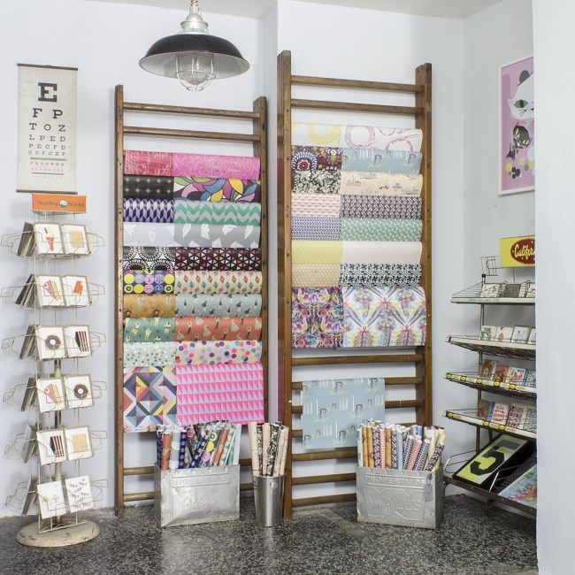 there are many different fabrics on display in the store, including quilts and fabric samples