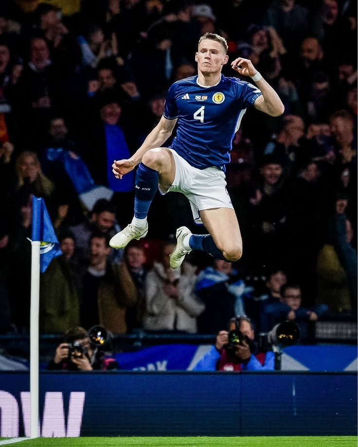 a man is jumping in the air to catch a soccer ball while people watch from the stands