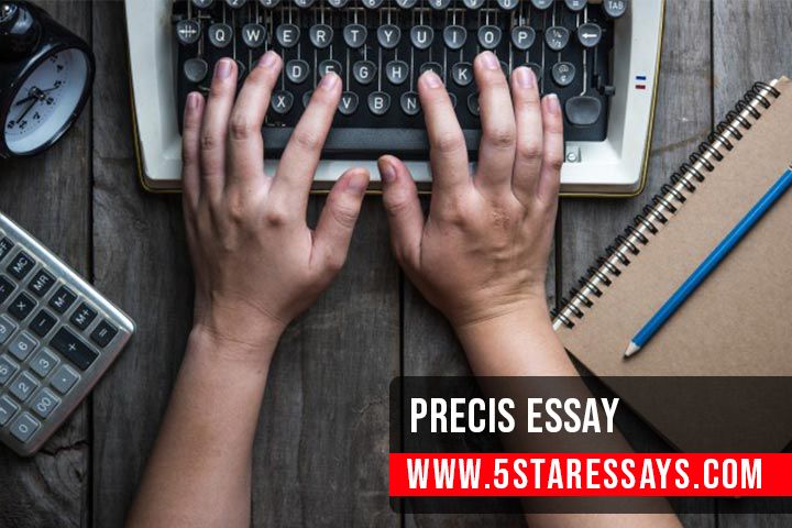 two hands typing on an old fashioned typewriter next to a notebook and calculator