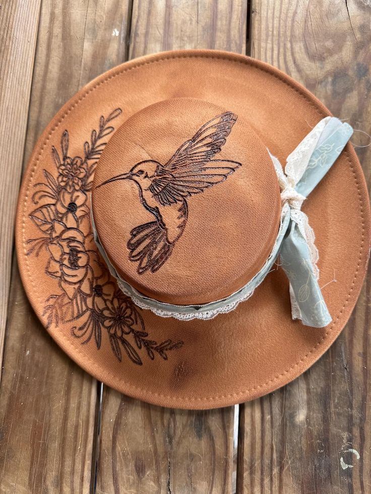 a brown hat with a hummingbird on it