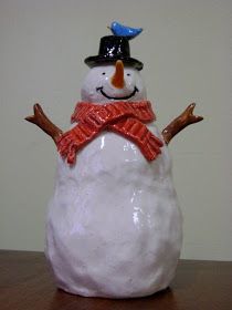 a white snowman sitting on top of a wooden table