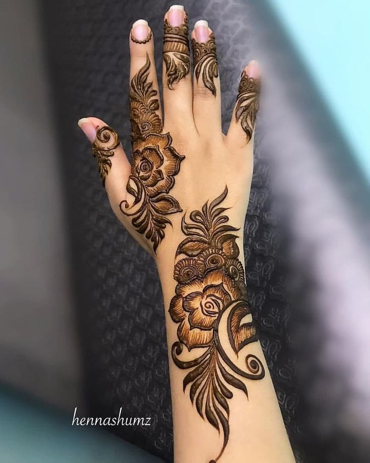 a woman's hand with henna tattoos on it