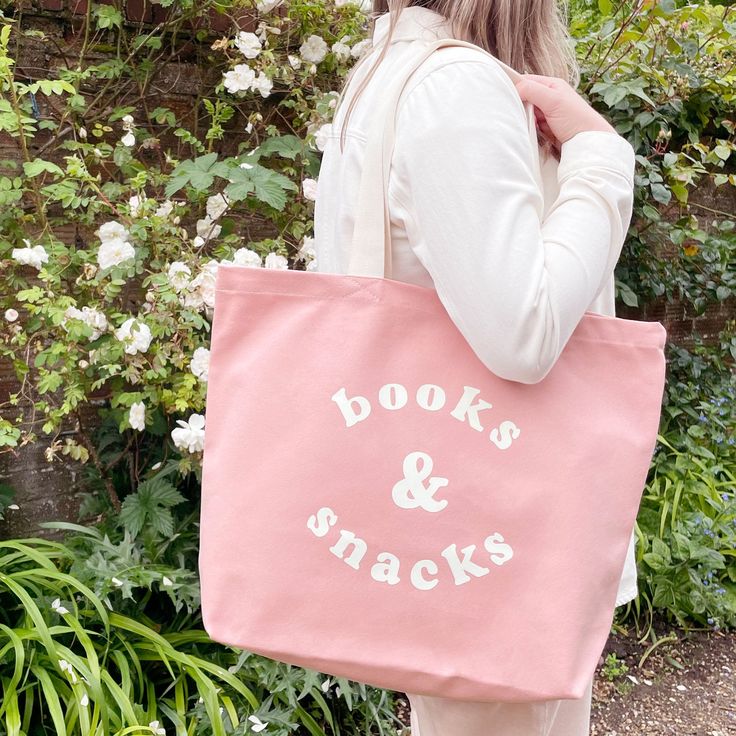 The perfect everyday tote for life's most important things, books and snacks! Our large canvas bags are the perfect spacious totes for your daily essentials and much more. Ideal for school, family days out, beach trips, you name it! A perfect gift for students, teachers, mums, and book & snack lovers everywhere. This hand illustrated 'Books & Snacks' design has been printed in off-white on sturdy blush pink canvas. Suitable for carrying by hand or over the shoulder. Lovingly designed and made in the UK. Made in the UK 15oz thick pink canvas Deep flat base Mid-length handles 480mm by 390mm by 120mm (19 by 15½ by 4¾ inches) Snacks Design, Pink Canvas Tote Bag, Books Kids Room, Gift For Students, Pink Books, Oversized Tote Bag, Pink Canvas, Family Days Out, Beach Trips