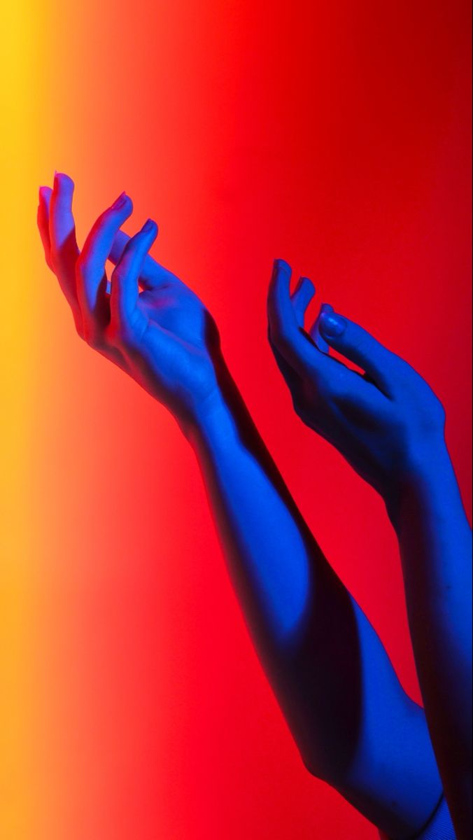 two hands reaching up in the air with colored background