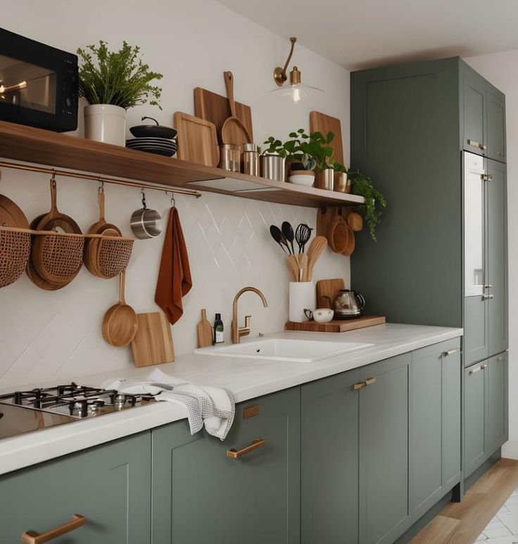 a kitchen with green cabinets and wooden utensils hanging on the wall above the sink