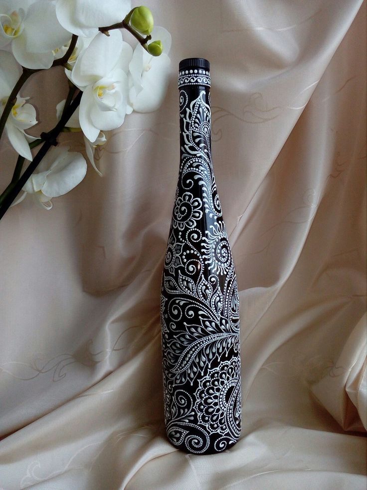 a black and white vase sitting on top of a table next to a bouquet of flowers