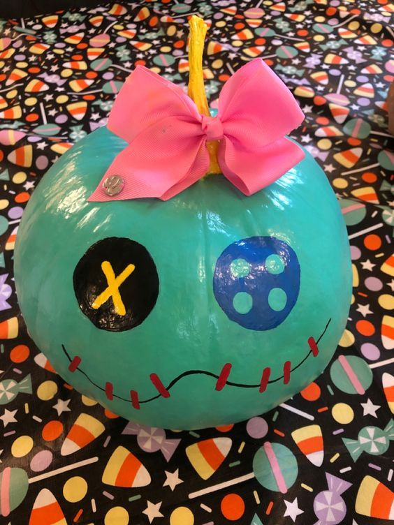 a blue pumpkin with a pink bow on it