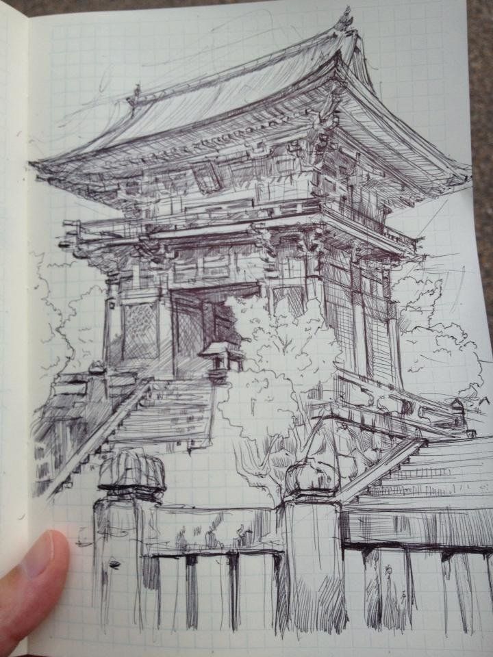 a hand is holding up a drawing of a chinese building with stairs and trees in the background