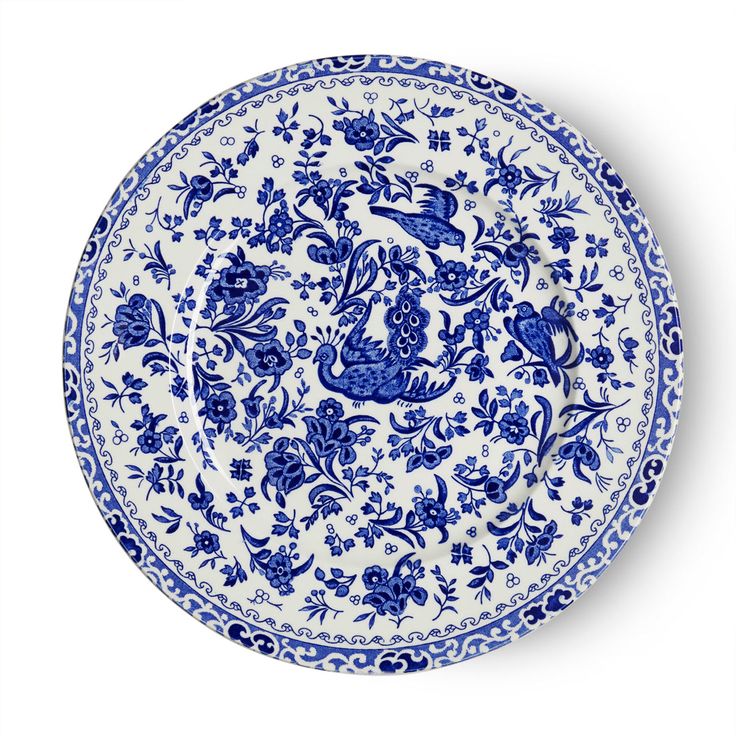 a blue and white plate with an ornate design on the rim, decorated with flowers and birds