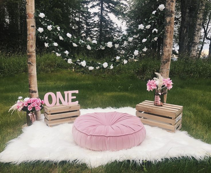 a pink bean bag chair sitting on top of a white rug next to two wooden crates