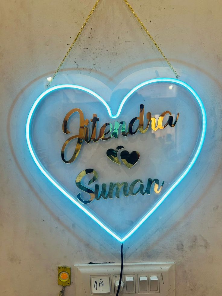 a heart shaped neon sign hanging from the side of a wall