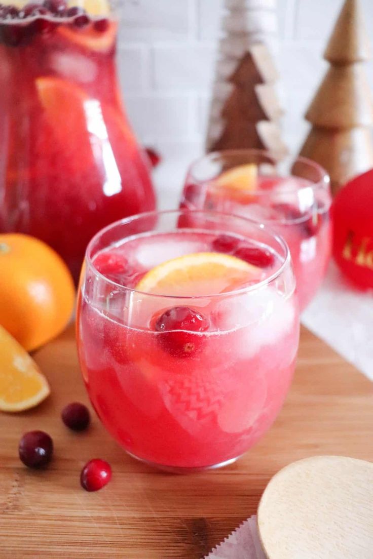 two glasses filled with cranberry lemonade on top of a wooden table