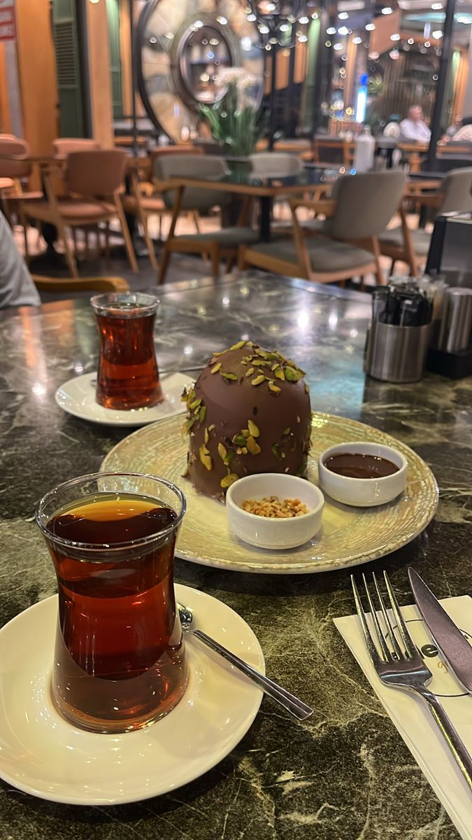 two plates with desserts on them sitting on a table in a restaurant or cafe