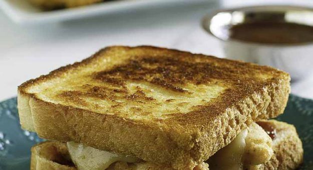 a grilled cheese sandwich sitting on top of a blue plate