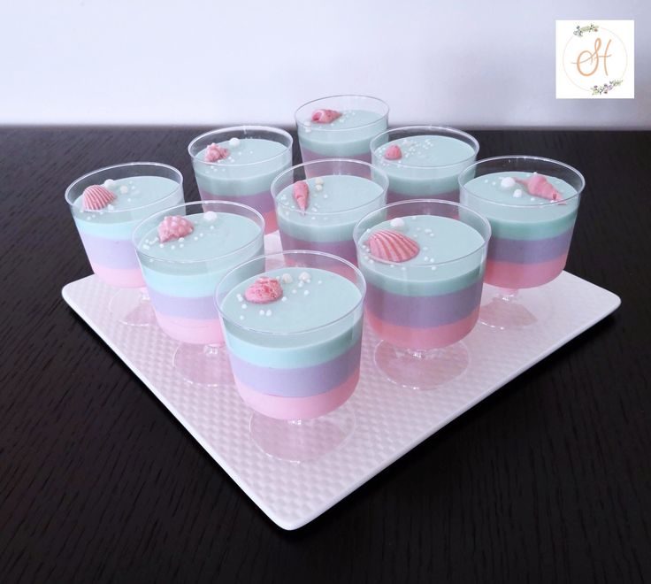 there are many cups that have shells in them on the tray and one is filled with jelly