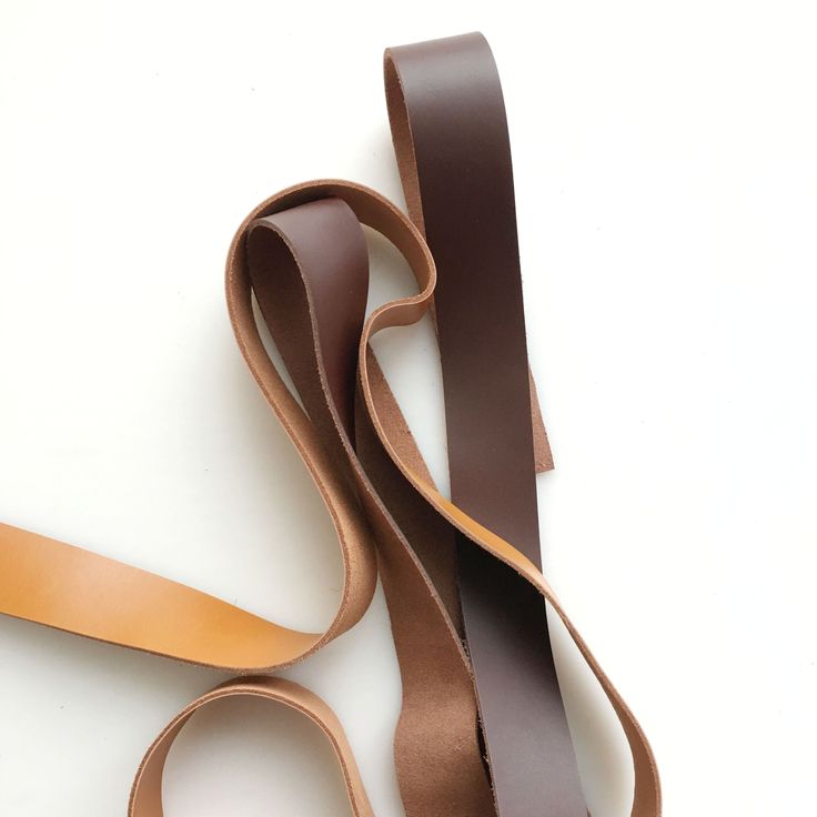 a pair of brown leather straps laying on top of each other