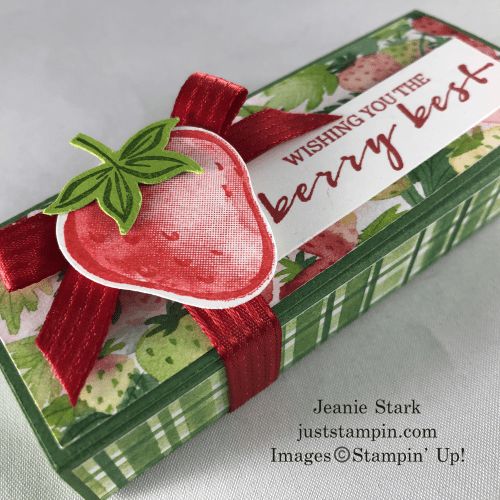 a small box with a strawberry on it and a ribbon around the edge that says, wishing you the berry best