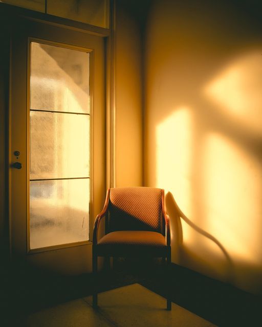 an empty chair sitting in front of a door