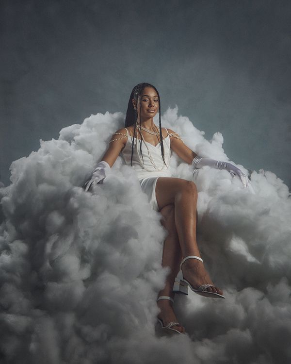 a woman sitting on top of a pile of clouds