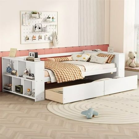 a white bed with drawers underneath it in a room