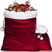 a red bag filled with christmas presents on top of a white table next to a santa hat