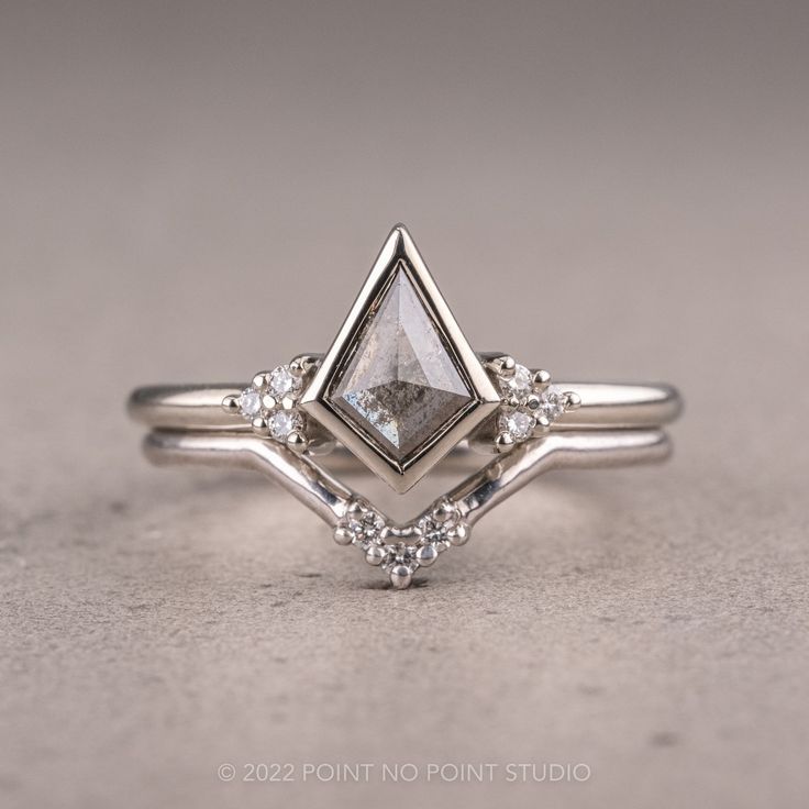 a white gold diamond ring with three diamonds on it's sides and the center stone in the middle